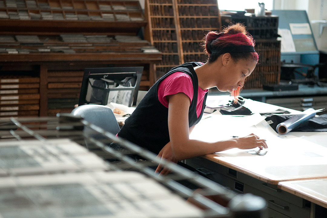 A Corcoran student inspects works in class