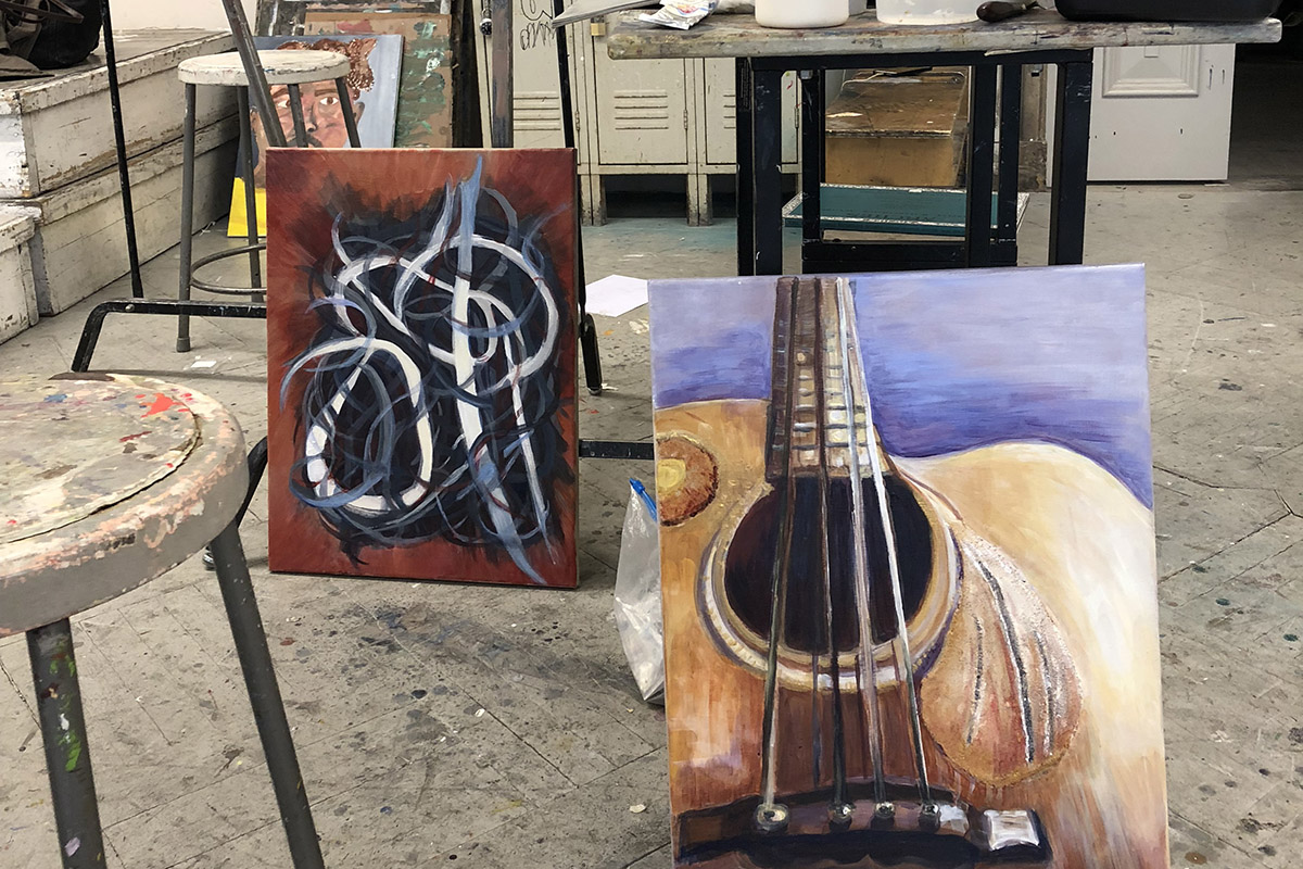 Paintings by Corcoran students sit in a workroom
